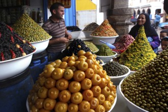 Dealer offers various pickled olives and lemons in the Essaouira souk, Essaouira, Morocco