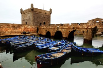 Blue-painted boats in front of the historic fortress and western bastion, Essaouira, Marrakesh-Safi