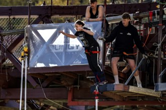 Female jumper ready to jump off a bridge surrounded by observers, Queenstown, Otago, New Zealand