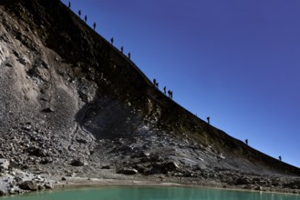 Descent along a steep crater trail at Mount Ngauruhoe under clear skies, Tongariro National Park,