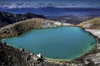 The emerald green lake is nestled in a barren volcanic landscape, Tongariro National Park, New