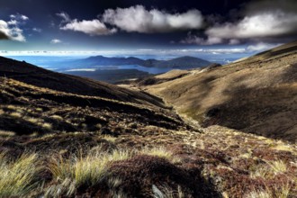 Wide ranges of hills open with views of Lake Taupo under dramatic clouds, Tongariro National Park,