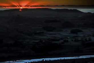 Dramatic sunrise behind mountain landscape with intense colors, Te Mata Peak, New Zealand