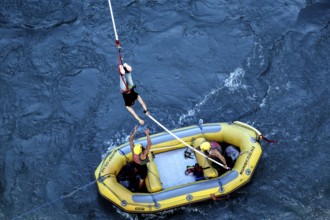 Bungee jumper is stopped over a yellow inflatable boat in the river, Queenstown, Otago, New Zealand
