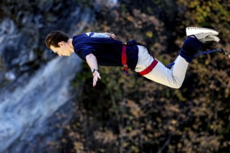 Jumper in horizontal prone position freefall over breathtaking landscape, Queenstown, Kawarau