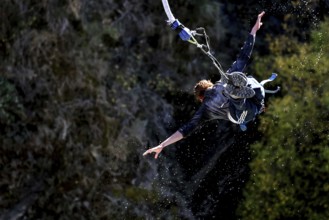 Person in a spread flight position bungee jumping over the countryside, Queenstown, Kawarau Bridge,