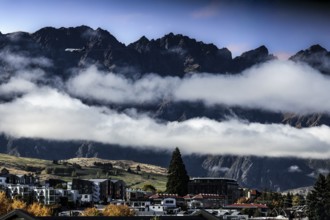 Impressive mountain landscape with clouds over the city of Queenstown, Queenstown, New Zealand