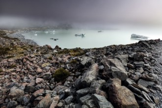 Cold glacial lake on Hocker Valley Track with rugged rocks and fog, Mt Cook, Hocker Valley Track,