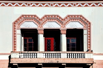 Close-up of an art deco balcony with geometric pattern and red doors, Napier, Hawke's Bay, New