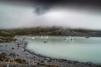 Glacial lake in misty Aoraki Mt Cook National Park with rugged shores, Mt Cook, Hocker Valley