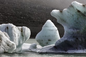 Contrasting ice blocks float in a cool glacial lake, Mount Cook, New Zealand