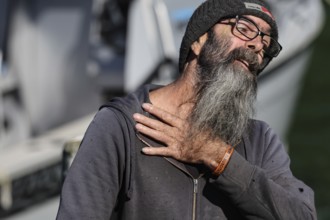 Man with long beard and glasses smiles during mail delivery at Pelorus Mailrun