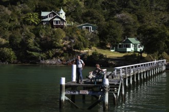 Timber house and pier on quiet Pelorus Sound, part of the mail delivery