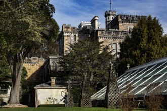 Front view of Larnach Castle surrounded by blooming garden, Otago Peninsula, New Zealand