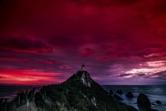 Lighthouse on Nugget Point under a dramatic red sunrise sky, Nugget Point, Otago, New Zealand