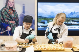 Two woman decorate dishes for Norway's stand at Green Week at the exhibition center in Berlin on 16