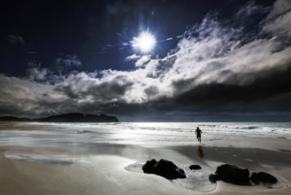 Sunny cloudy sky on Hot Water Beach with lonely figure on the beach, Hot Water Beach, Coromandel