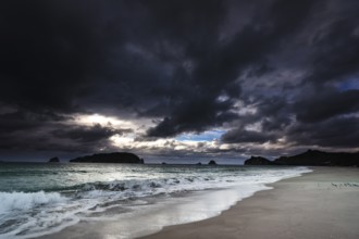 Dramatic sky over Hahei beach, dark clouds and rushing waves, Hahei, Coromandel Peninsula, New
