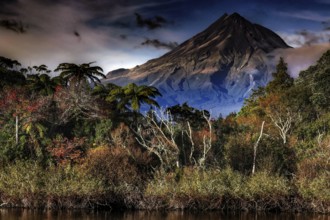 Majestic view of Mount Taranaki from Lake Mangamahoe surrounded by trees, Mount Taranaki, New