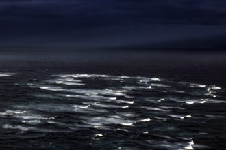 Gloomy image of the confluence of the Tasman Sea and Pacific with surging waves, Cape Reinga,