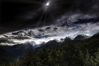 Dramatic snow-covered mountain landscape under a cloudy sky, Milford Road, New Zealand