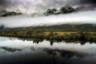 Mountain landscape with dramatic sky is clearly reflected in the calm lake, Mirror Lakes, New