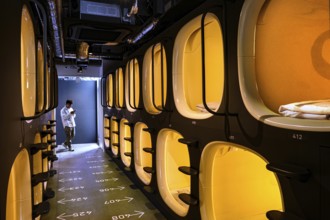 Aisle of a modern capsule hotel with illuminated sleeping capsules, Tokyo, zero, Japan