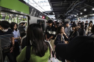 Passengers get off a train on a crowded platform in Tokyo, Tokyo, Japan