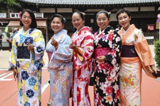 Group of woman wearing colorful kimonos against a traditional backdrop in Tokyo, Tokyo, Asakusa,