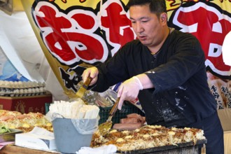 A chef prepares okonomiyaki at a food market during Sanj Matsuri in Asakusa, Tokyo, Asakusa, Japan