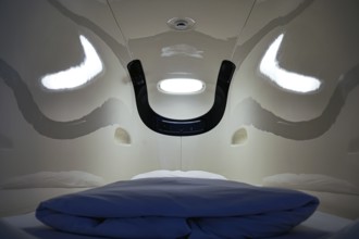 Interior of a capsule hotel sleeping capsule, futuristic design with blue pillow, Tokyo, zero,