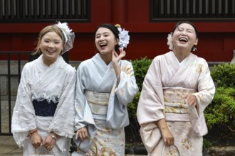Three woman in traditional kimonos laugh in front of Senso-ji in Asakusa, Tokyo, Asakusa, Japan