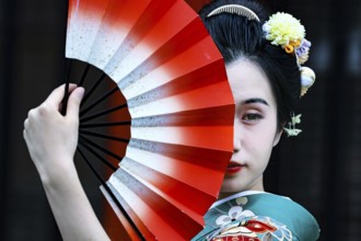 Elegant woman wearing green kimono with fans in front of Senso-ji in Asakusa, Tokyo, Asakusa, Japan
