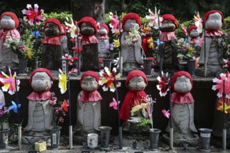 Many jizo statues with red cloths and wind turbines at Zojo-ji Shrine in Minato, Tokyo, Tokyo,