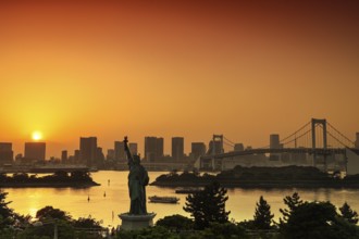 Statue of Liberty and Rainbow Bridge in the background of a sunset, Tokyo, Japan