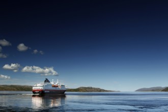 Hurtigruten ship on calm sea with bright sky, Kirkenes, Finnmark, Norway