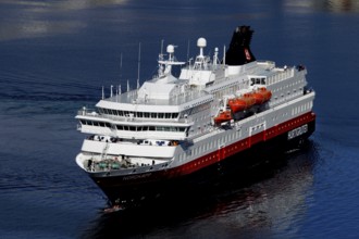 Hurtigruten ship on calm seas in sunny weather near Hammerfest, Hammerfest, Finnmark, Norway