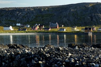 View of Hamningberg with kittiwakes along the coast and reflections in the water
