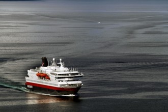Hurtigruten ferry sails through calm sea near Hammerfest, Hammerfest, Finnmark, Norway