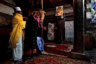 Two men in traditional robes in the richly decorated monastery church, Debre Damo, Tigray, Ethiopia