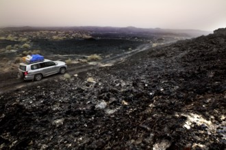 Travel through a barren lava desert with a Landcruiser on a gravel road