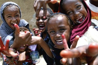 Laughing children in Harar with bright smiles and playful gesture, Harar, Oromia, Ethiopia