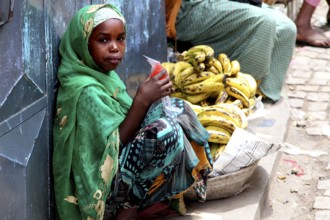 Child banana saleswoman wearing traditional clothes in the old town of Harar, Harar, null