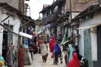 Lively tailor's alley in the old town of Harar filled with people wearing traditional clothes,