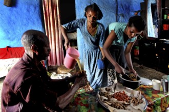 Family visit to Lalibela, two woman preparing meal on table, Lalibela, zero