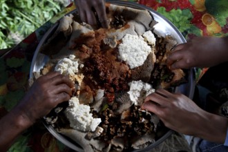 Eating together on a large food platter with Injera with Chuchu's family in Lalibela, Lalibela,