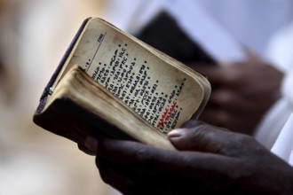 Close-up of a Bible in hands, symbolic religious practice in Lalibela, Lalibela, Amhara, Ethiopia