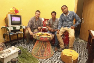 Conversation among men visiting with traditional food, Lalibela, Ethiopia