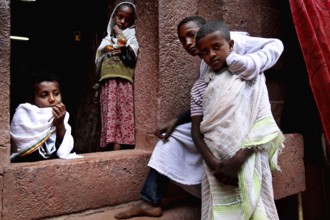 Children looking out of a window at Bete Emanuel church in Lalibela, Lalibela, Amhara, Ethiopia