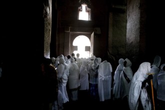 Believers wearing white clothes pray inside Bete Medhane Alem, Lalibela, Amhara, Ethiopia